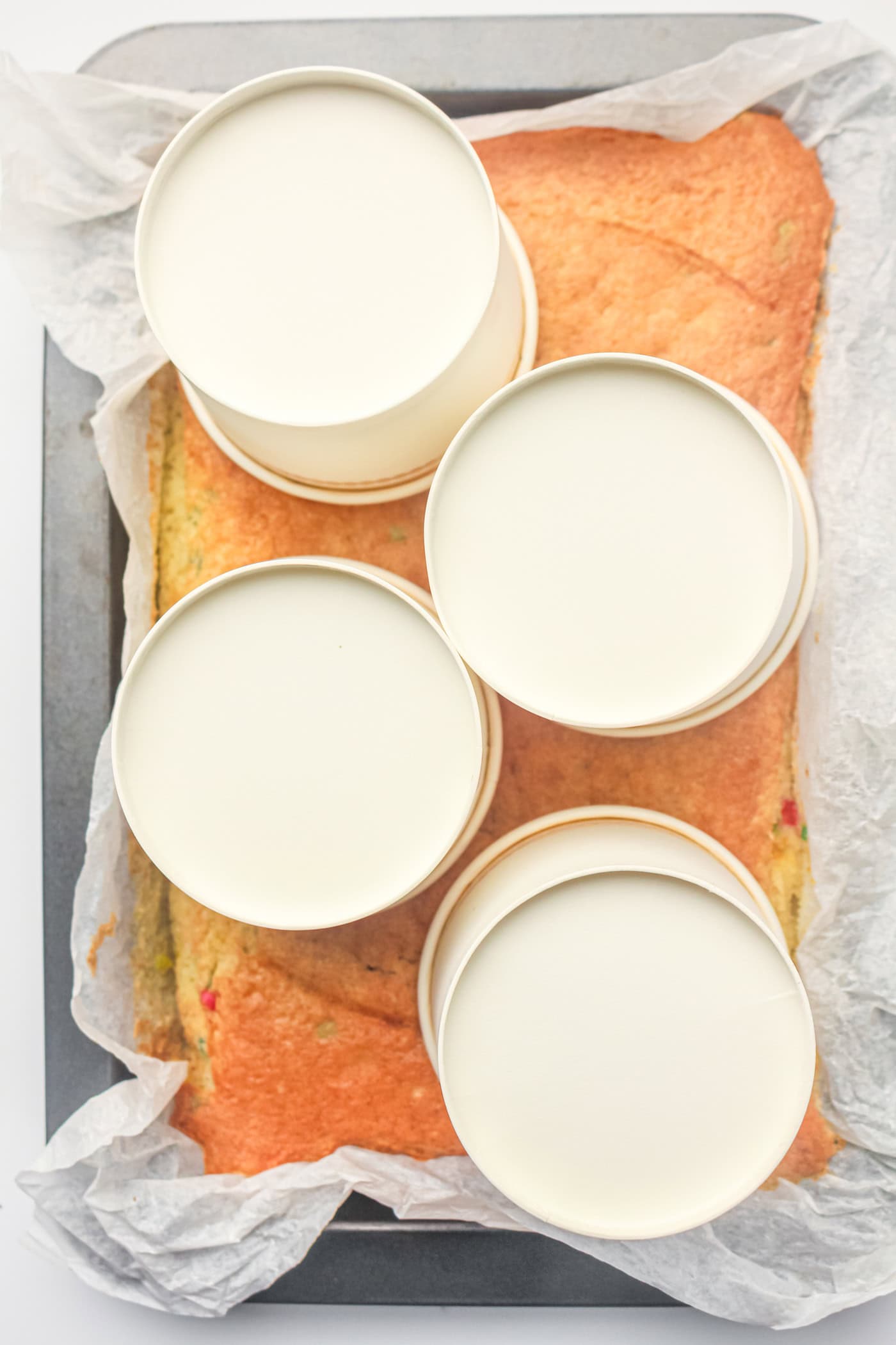 pressing paper dessert cups into a cake to make gluten free dot cakes