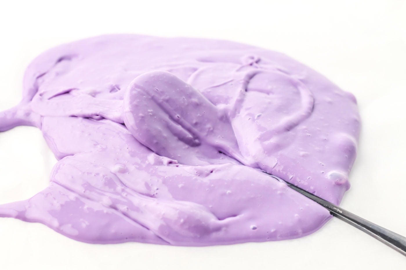purple homemade cleaning slime with a spoon