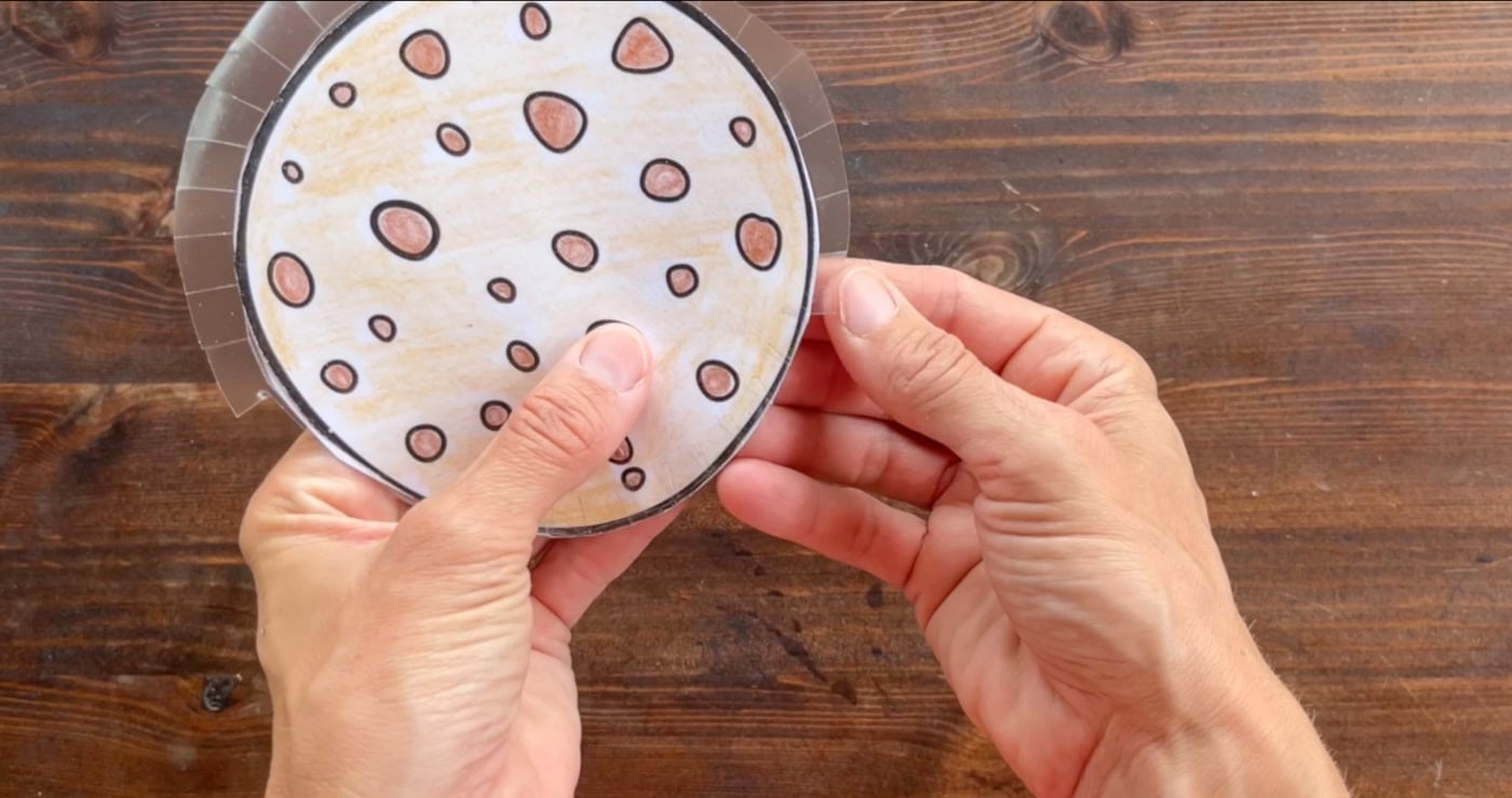 sticking the back and front pf a paper squishy together by folding over contact paper tabs
