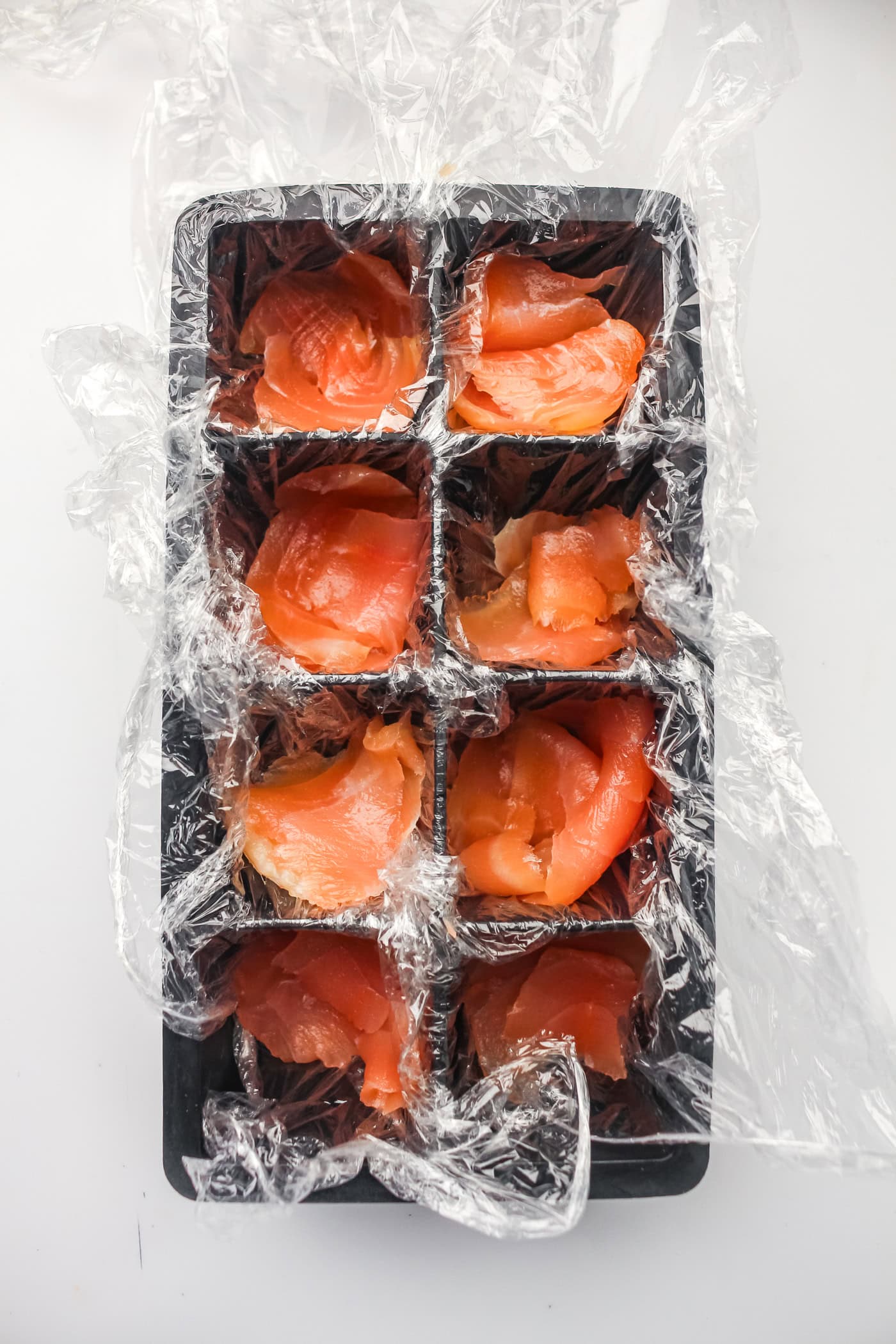 adding salmon to make ice cube tray sushi salmon rolls