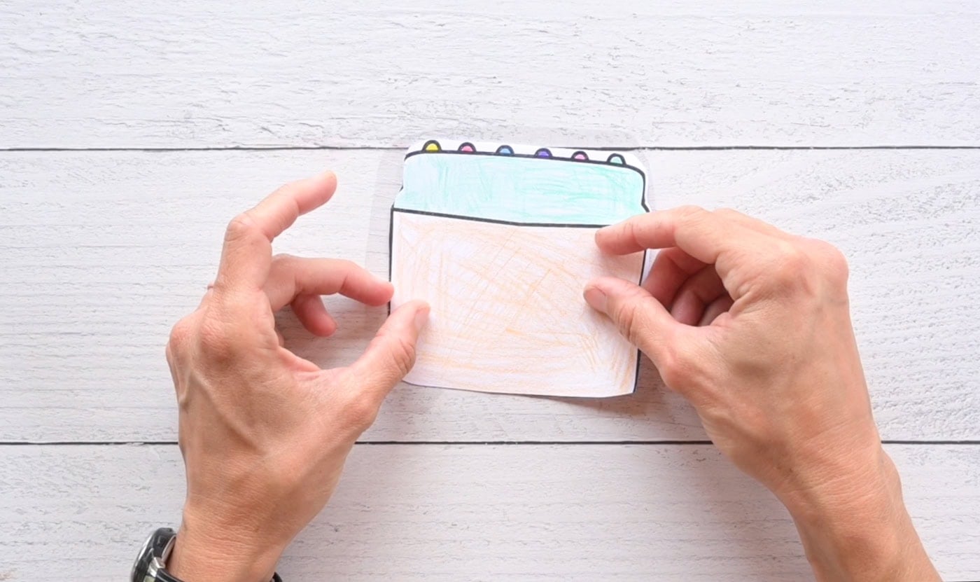 placing the back piece of a box of crayons squishy temple onto the front piece