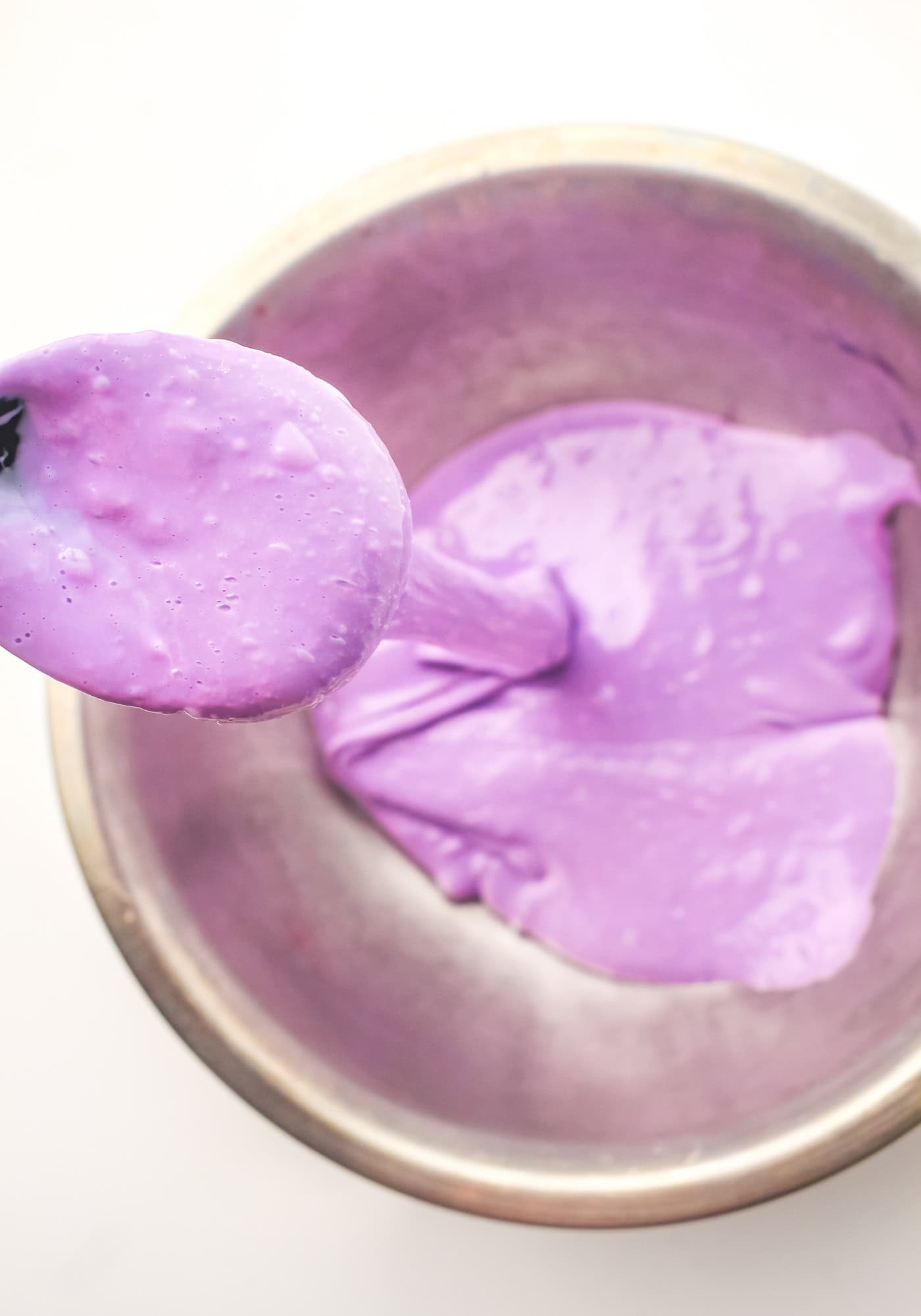 purple slime dripping off a spoon into a bowl