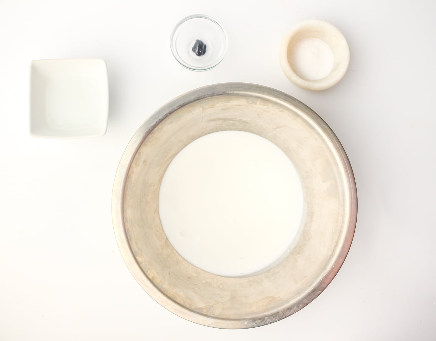 ingredients for DIY sensory slime on a white background. The ingredients are in various small bowls.