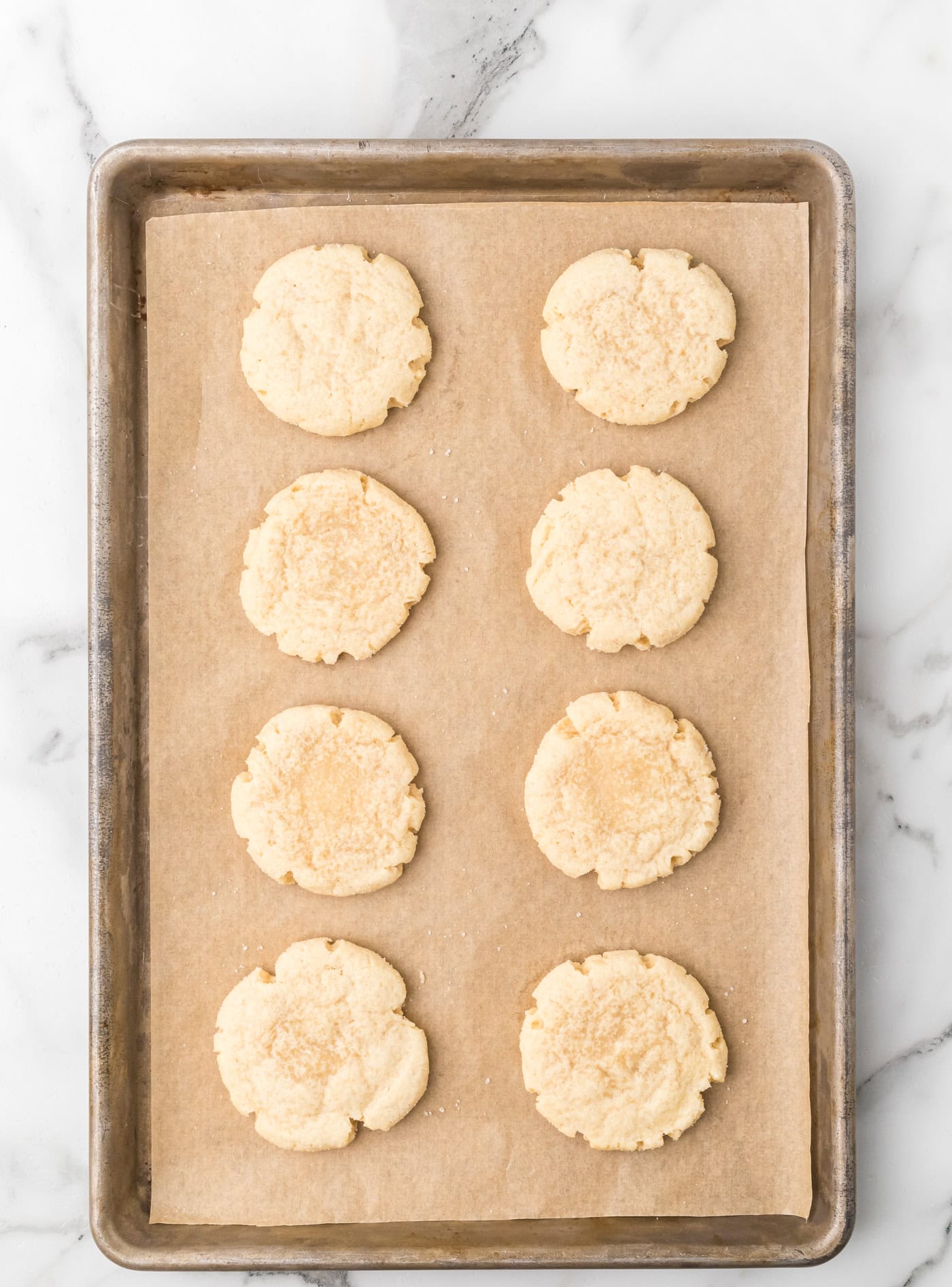 sourdough discard sugar cookies on a baking sheet after coming out of the oven