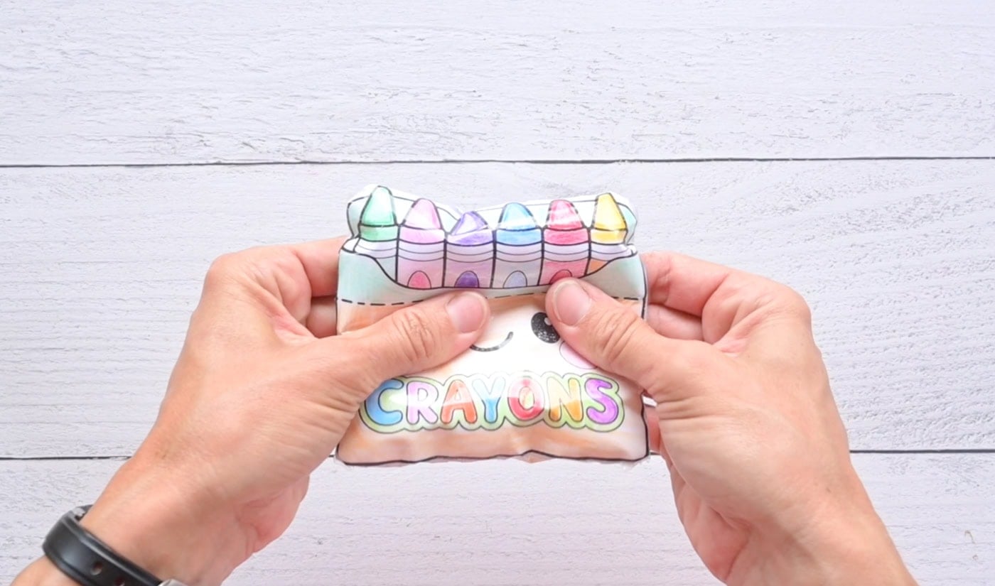 hands squishing a box of crayons paper squishy