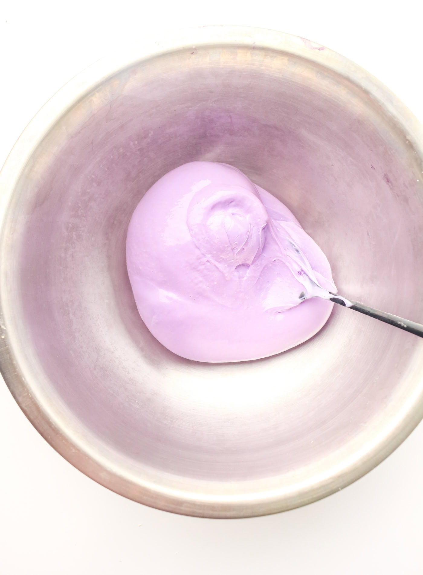 stirring DIY sensory slime in a bowl