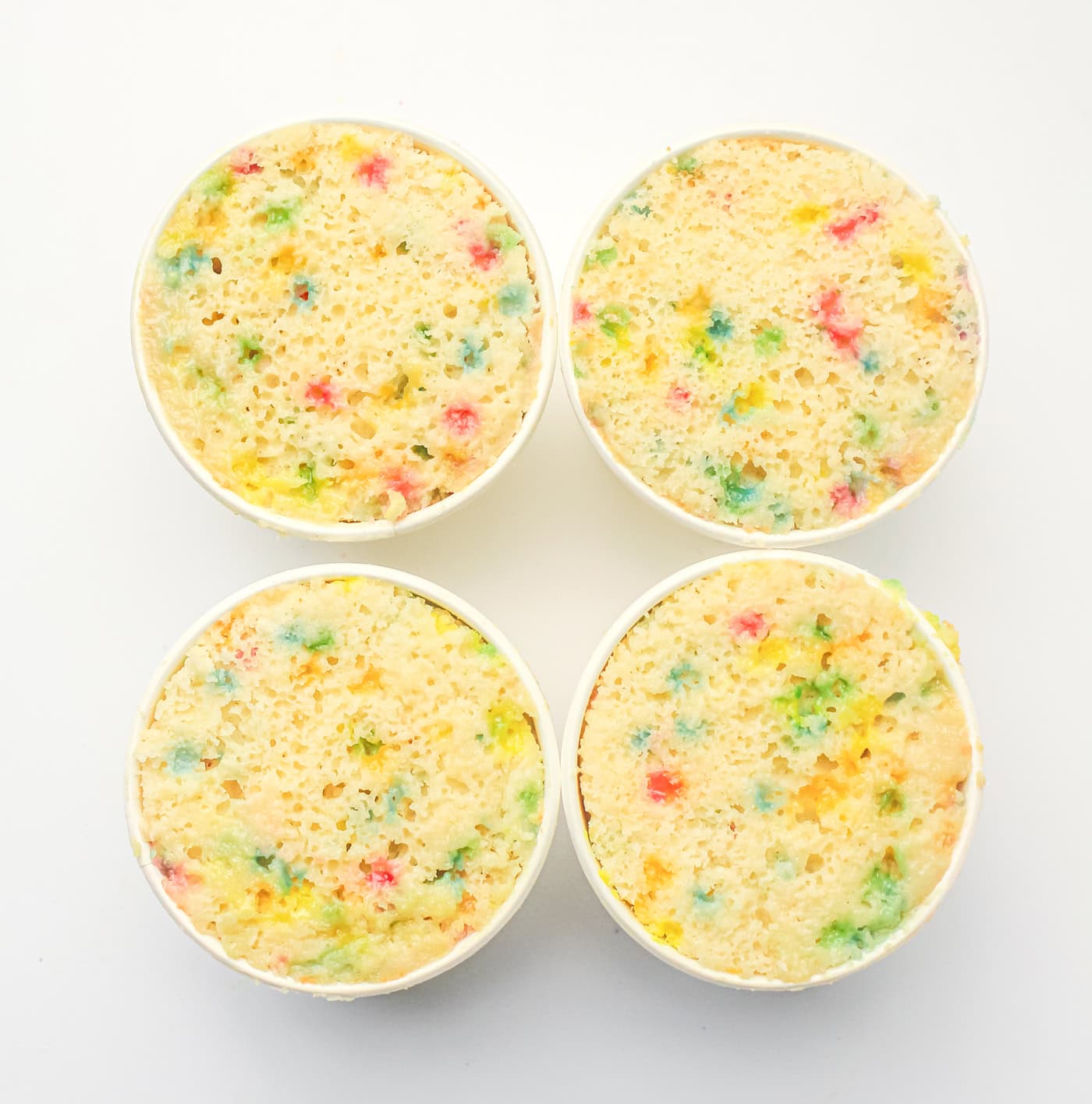 four paper cups with gluten ree dot cakes make with DIY funfetti cake mix