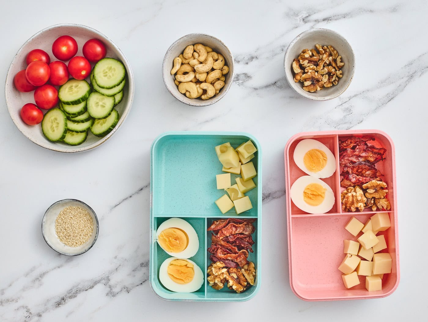 top down photo with two bento style lunchboxes with eggs, cheese, and bacon