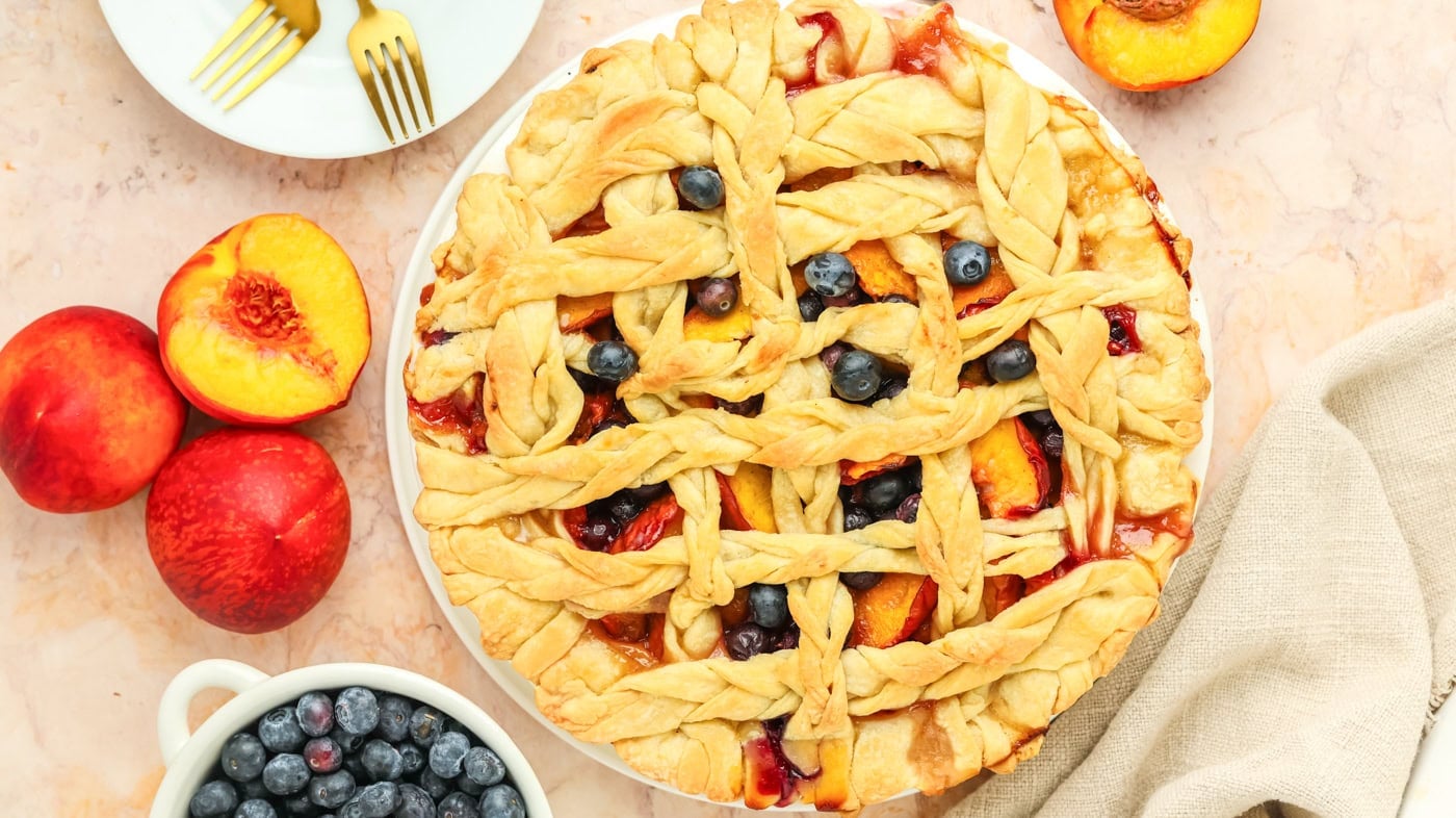 a top down image of a blurry peach pie with a lattice top crust