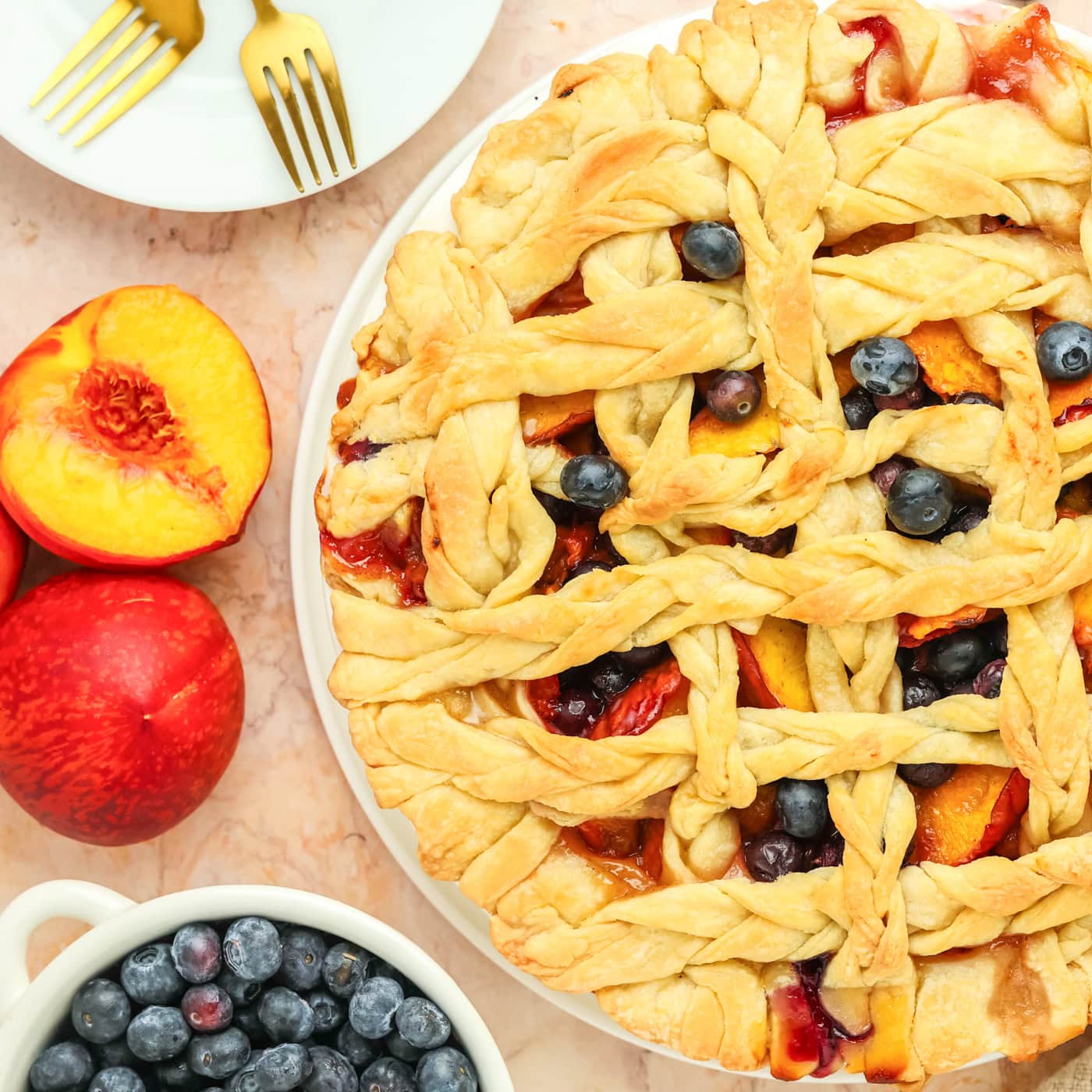 a baked peach and blueberry pie with a lattice top