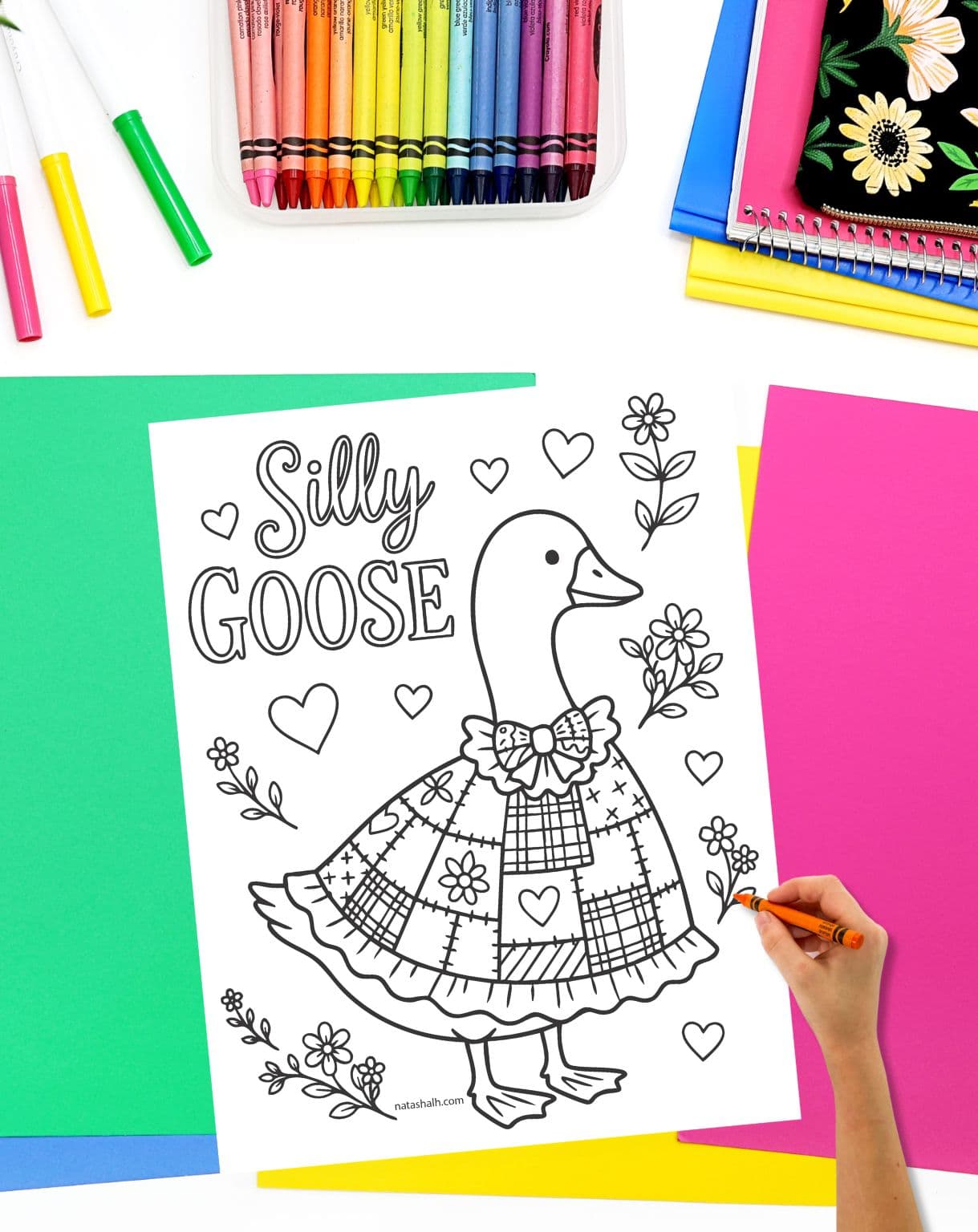 a hadn't with a crayon preparing to color a coloring page showing a goose wearing a quilt with the caption "silly goose"