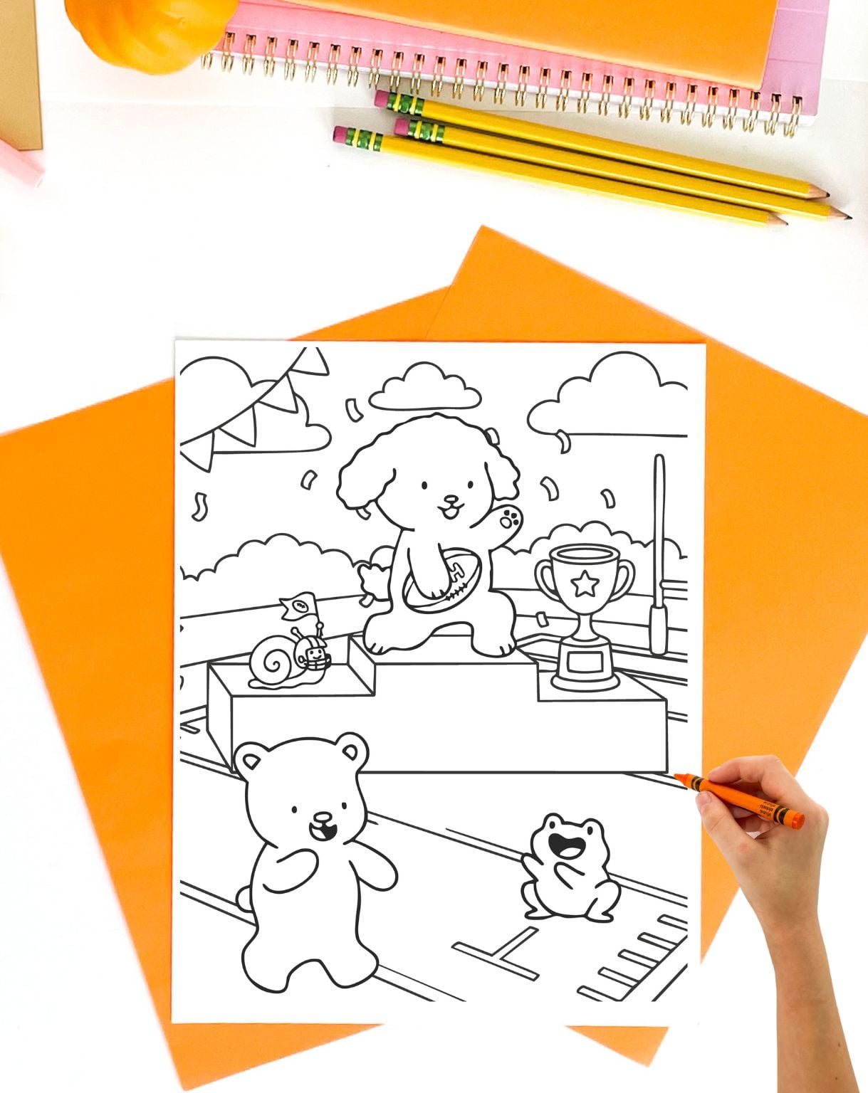 a hand with a crayon preparing to color a body and easy style coloring page showing cute animals accepting a football trophy