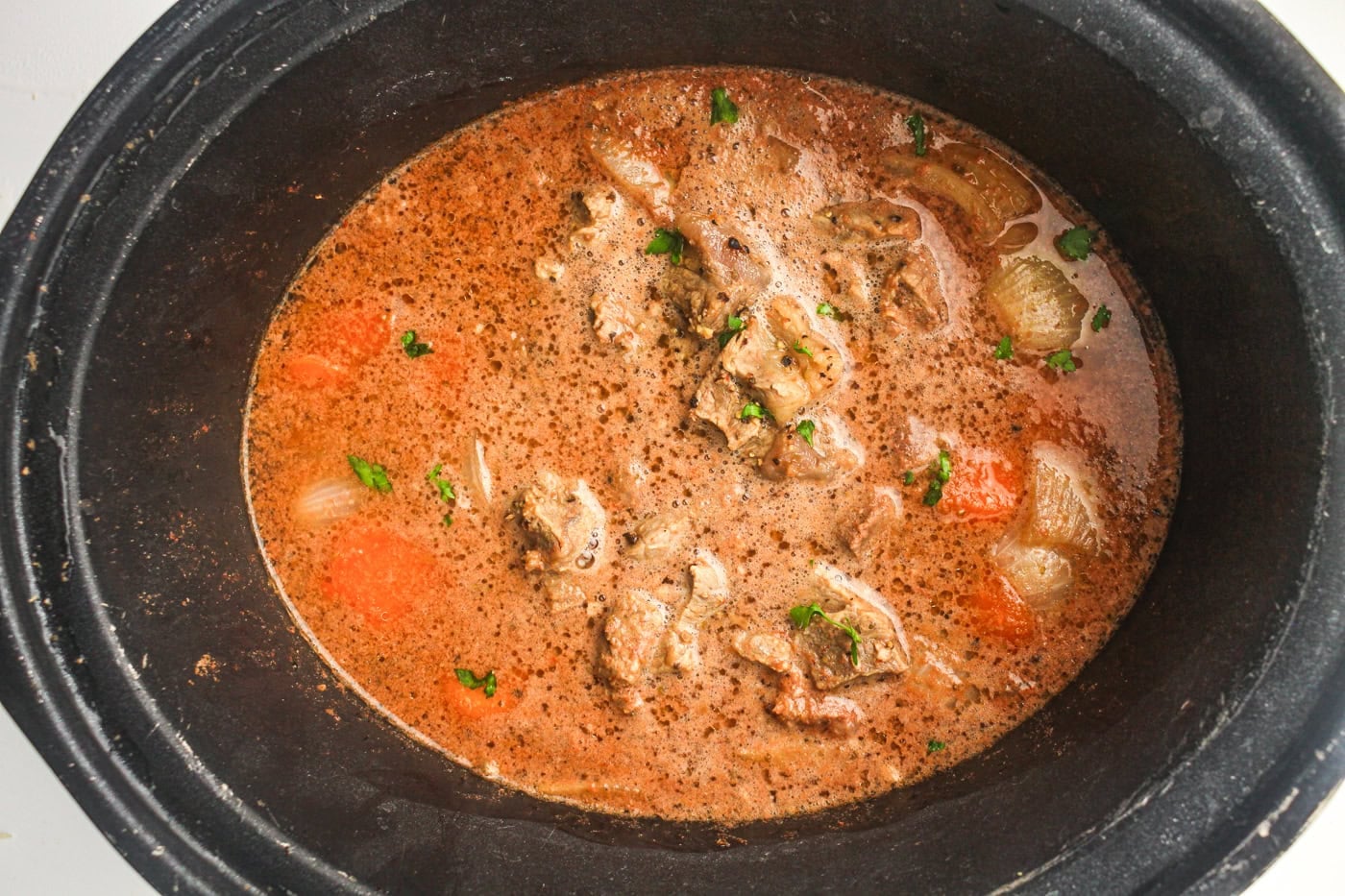 cooked beef stew in a. slow cooker crock