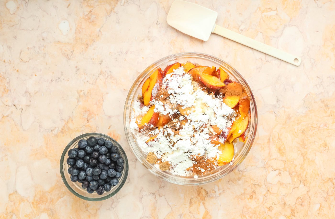 peaches in a bowl tossed with sugar and cornstarch