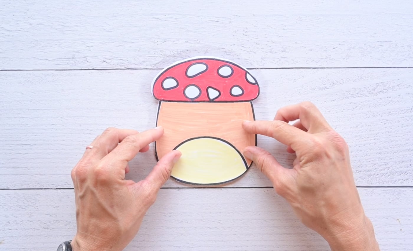 placing the back and front pieces of a mushroom paper squishy together
