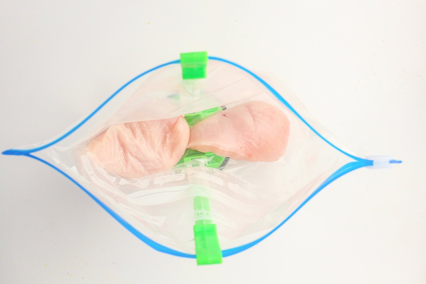 chicken in a gallon bag being held open by a bag holder