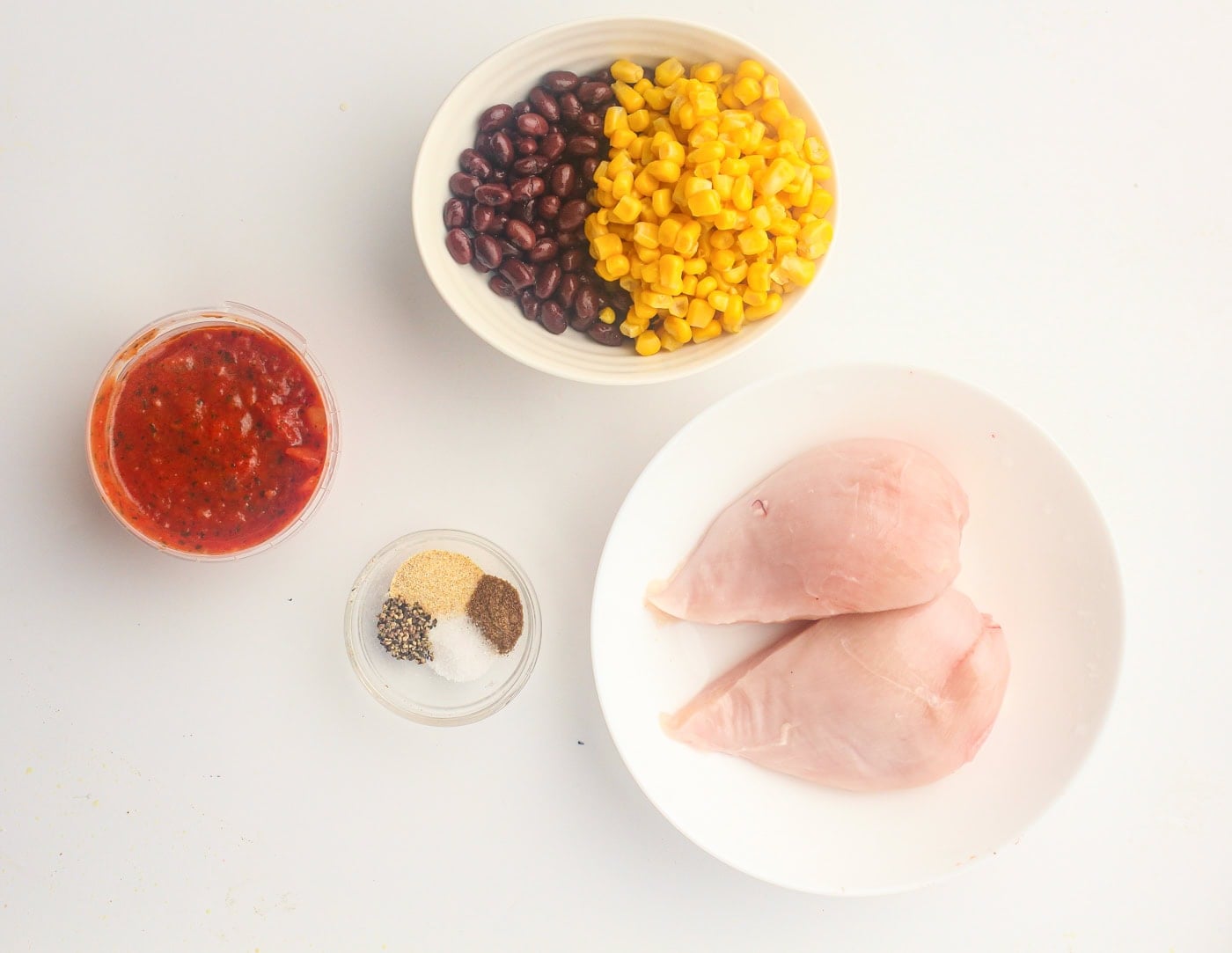 ingredients for salsa slow cooker chicken on a white background