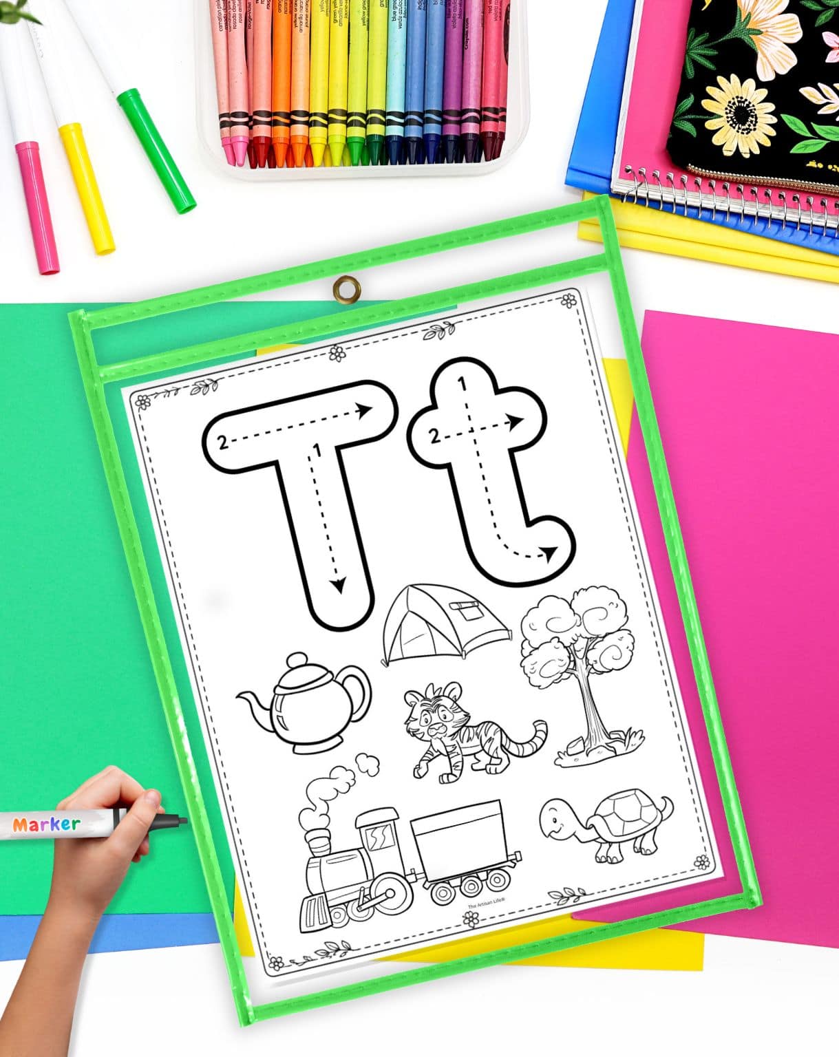 a hand with a dry erase marker preparing to use a letter t tracing page in a dry erase pocket