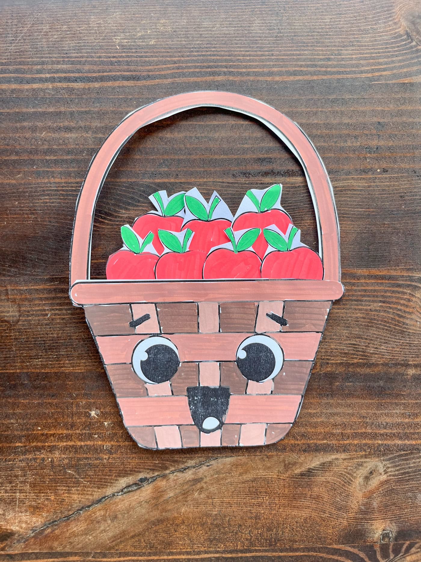 a completed cut and color apple basket craft for kids with five apples