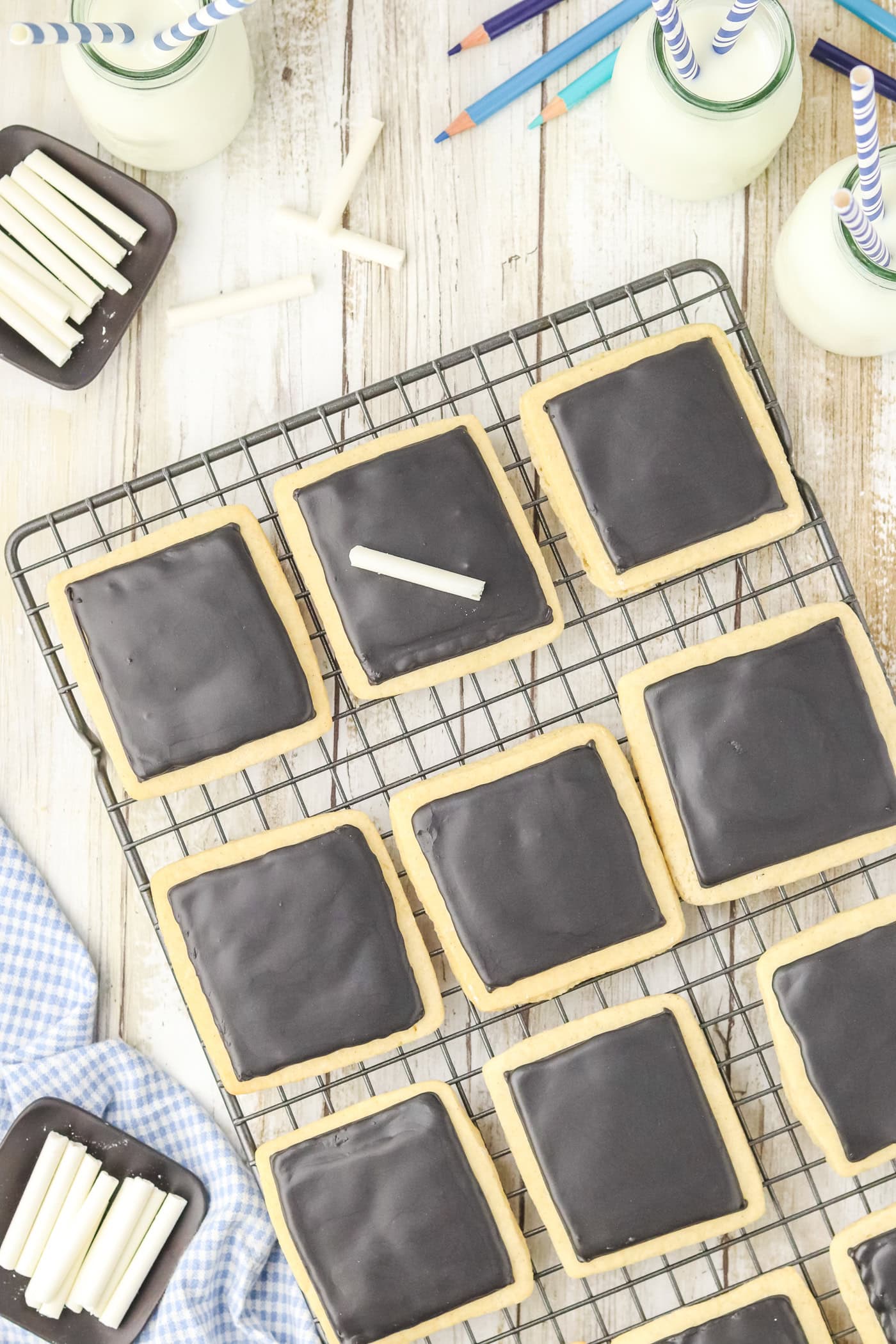 a top down view of a wire cooling rack of chalkboard sugar cookies ready to decorate with edible chalk