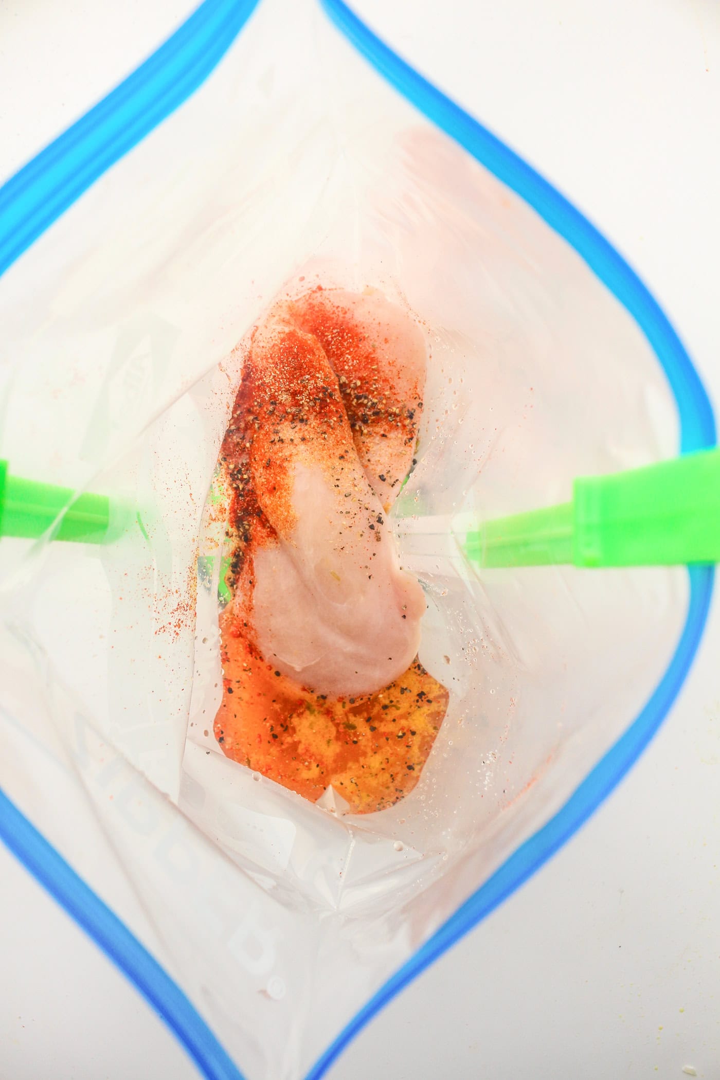 using a bag holder to hold a gallon ziplock bag open to add ingredients for slow cooker honey bbq chicken