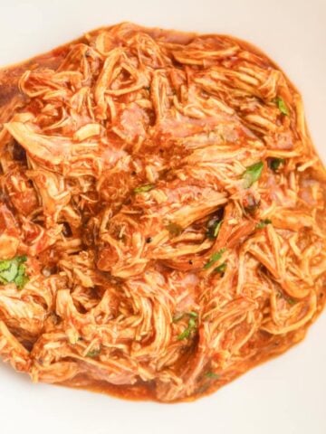 a top down photo of a bowl of slow cooker shredded honey bbq chicken