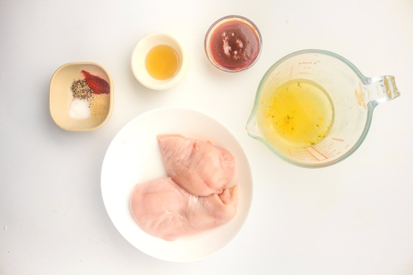 a top down photo of uncooked ingredients for honey bbq chicken in the slow cooker