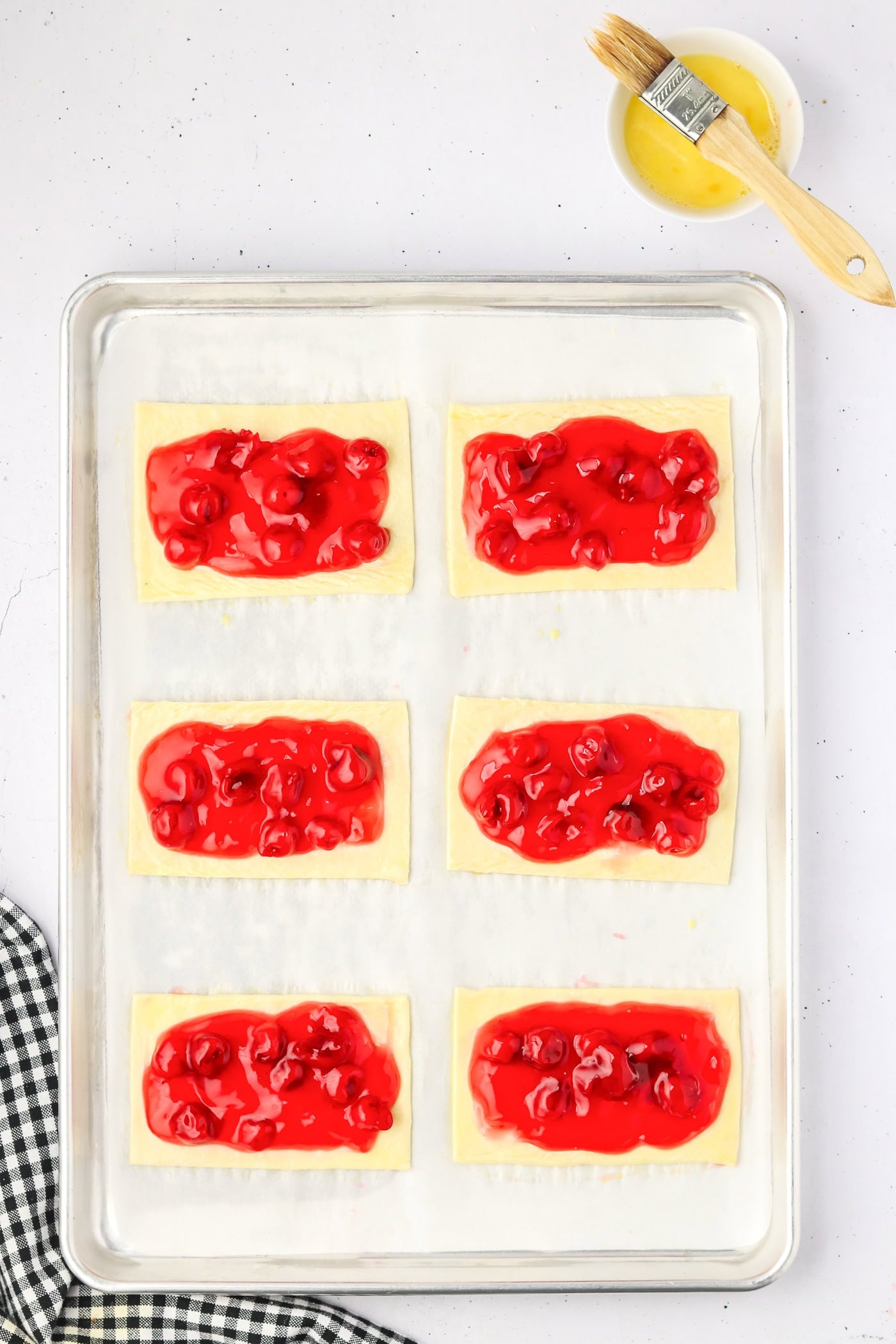 spreading cherry pie filling on rectangles of puff pastry