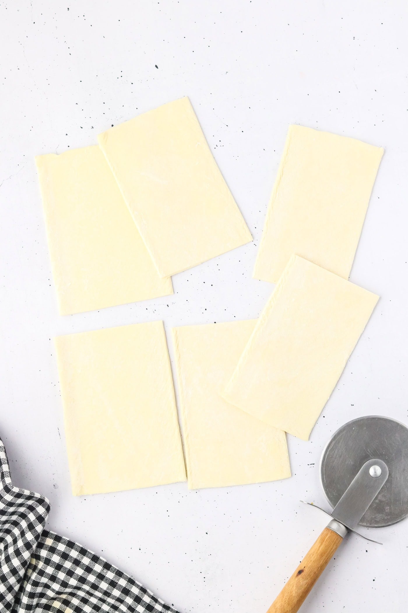cutting rectangles of puff pastry with a pizza wheel