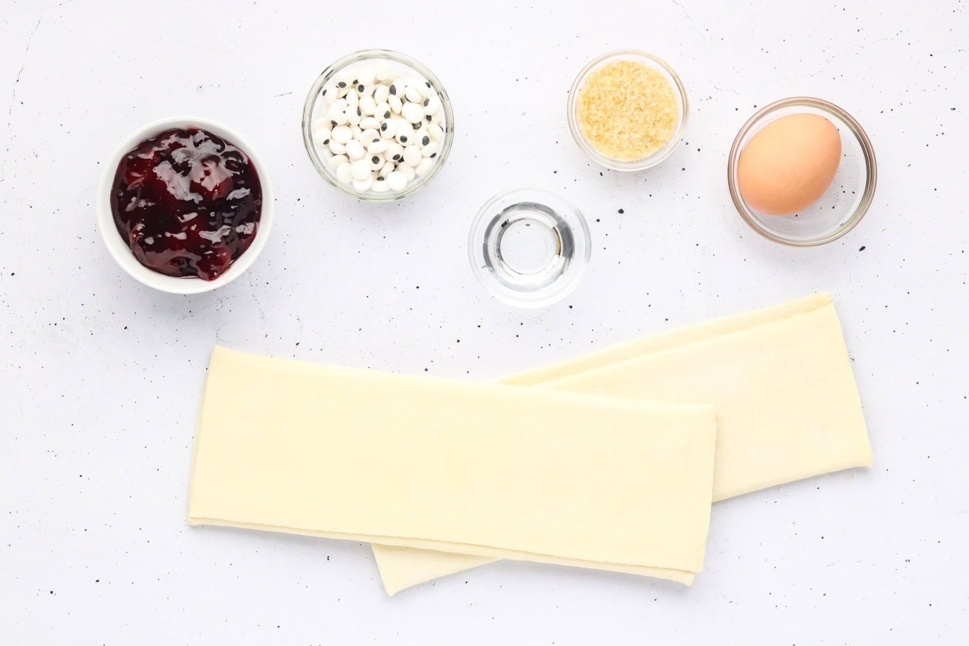 puff pastry, candy eyeballs, sugar, water, an egg, and pie filling to make mummy pastries