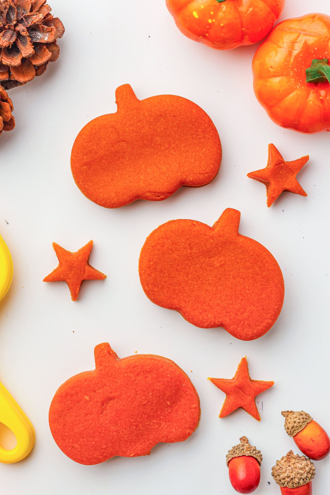 three pumpkin shapes cut from play dough and three play dough stars