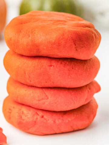 a stack of four disks of homemade orange play dough for fall