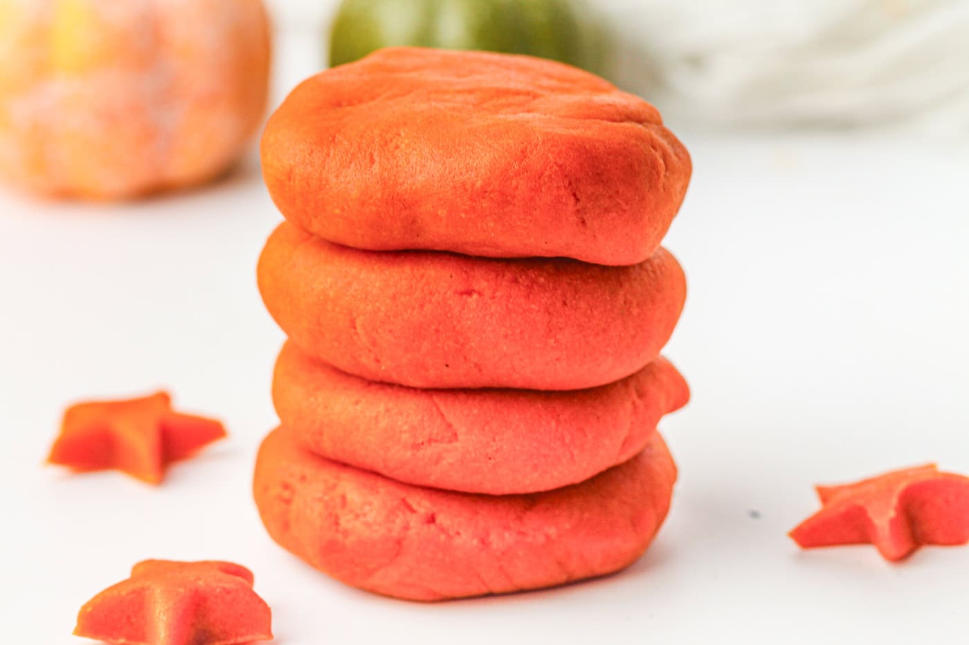 a stack of four disks of homemade orange play dough for fall