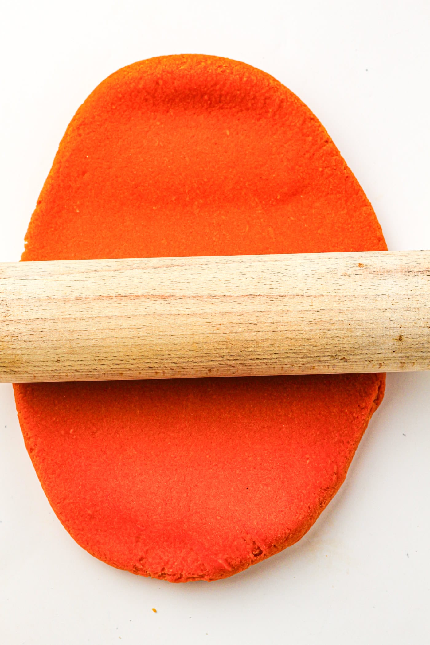 rolling out homemade fall play dough with a rolling pin