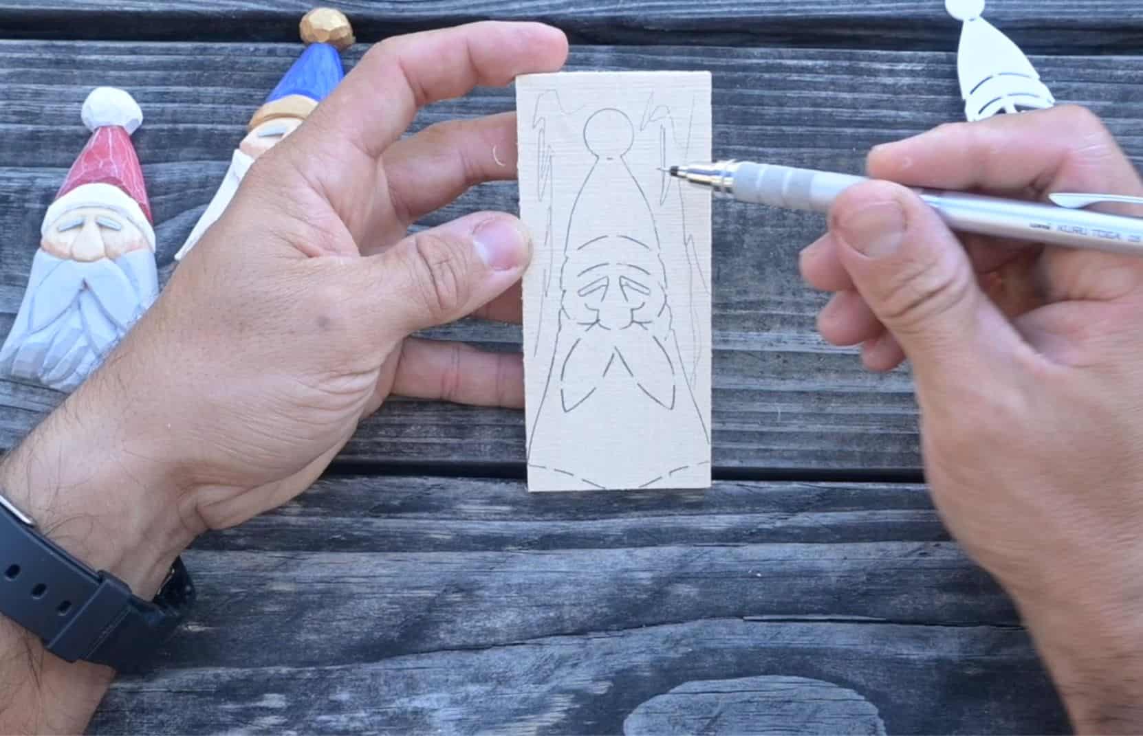 a santa face ornament sketched onto a block of wood