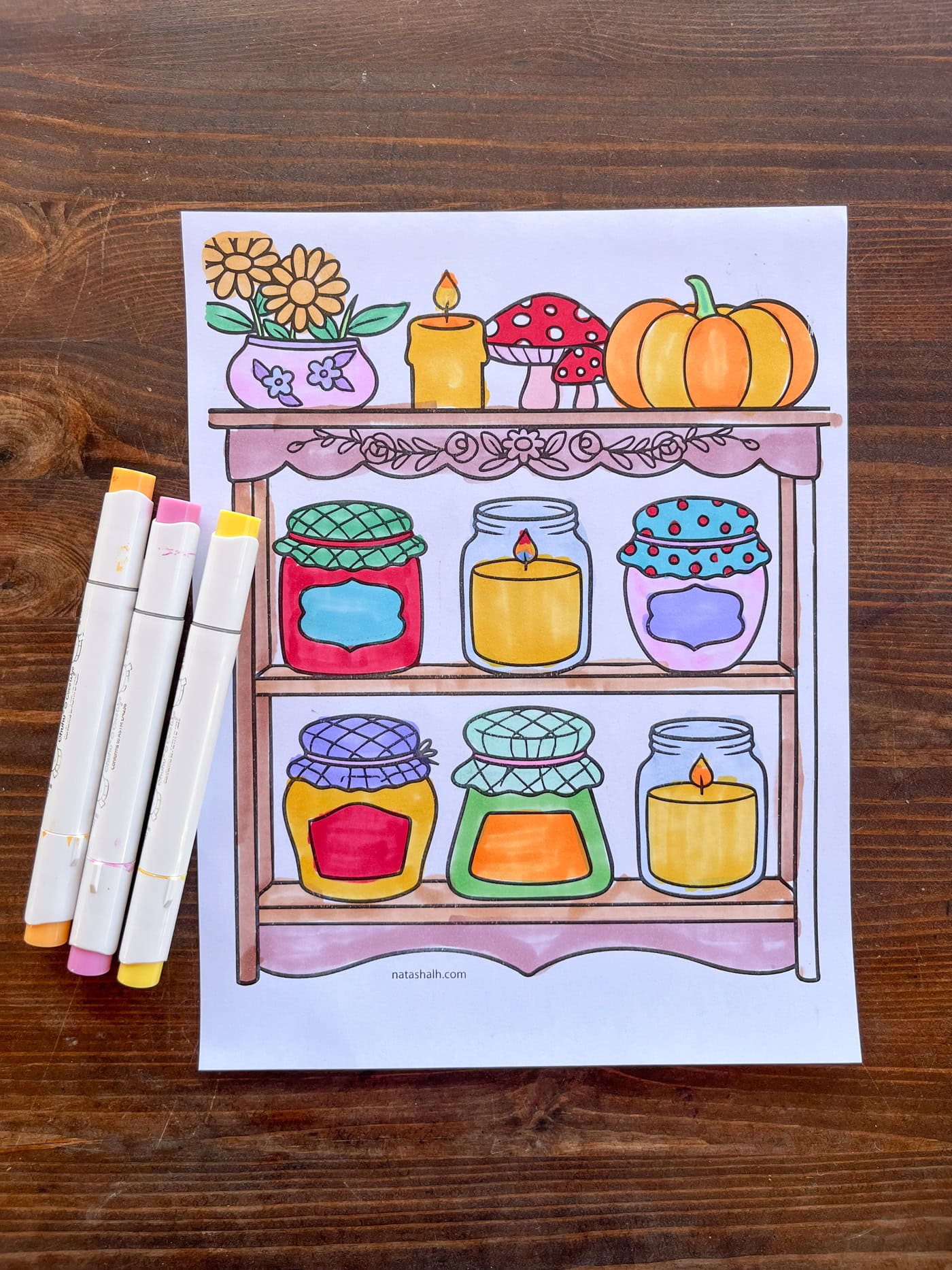 a hand colored fall coloring sheet showing pumpkins, candles, and jars of jam