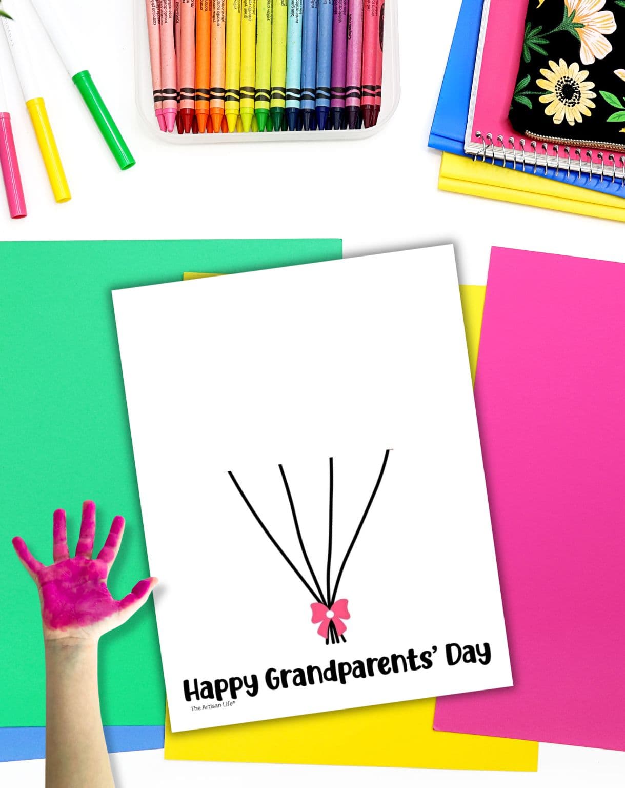 a hand with pink paint over a blank grandparent's day handprint craft template