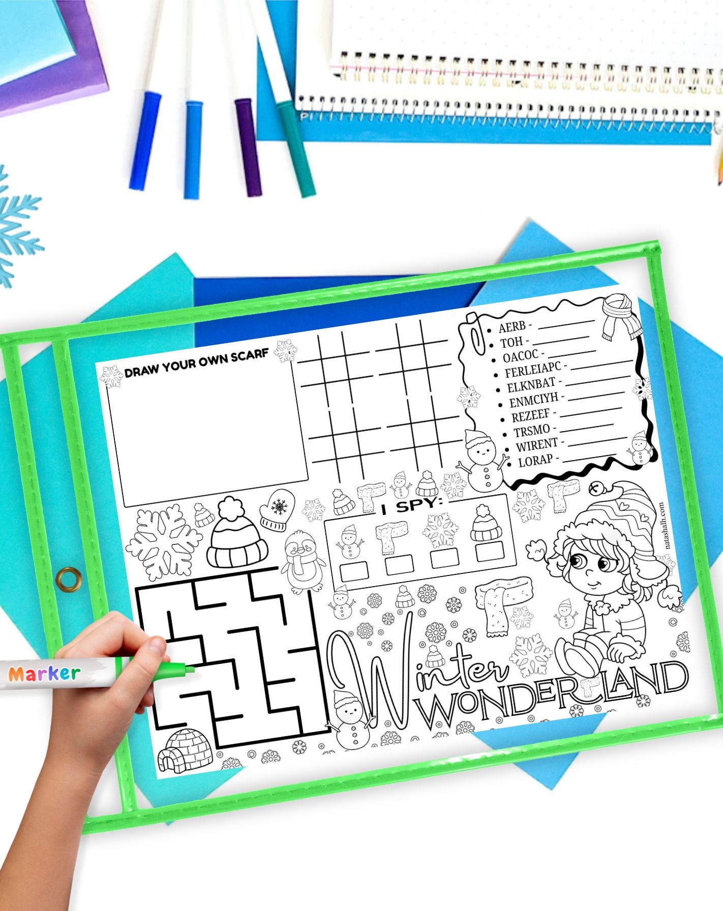 a winter activity placemat in a dry erase pocket on a. table with winter themed stationary items