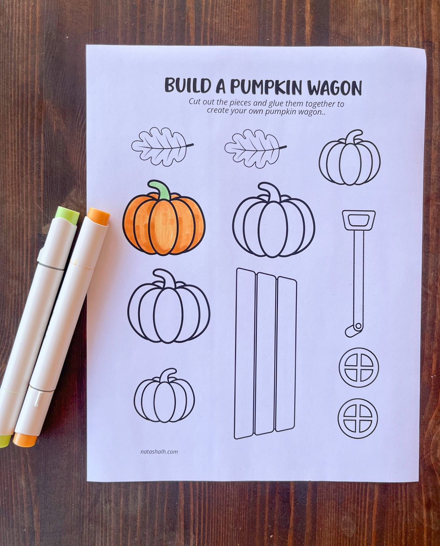 a photo of a pumpkin wagon cut and paste craft with one pumpkin colored